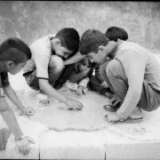 Children play checkers on the sidewalk